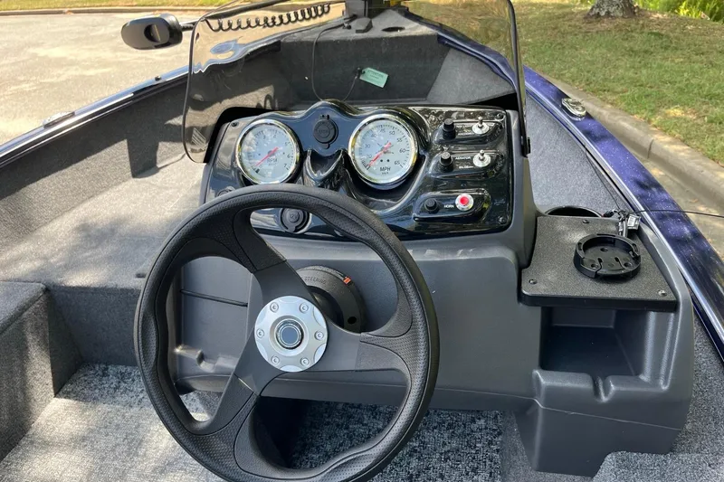 Slide: The Image of 2026 Tracker Super Guide V-16 SC boat dashboard with steering wheel and gauges. - 8