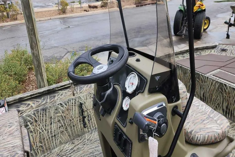 Slide: The Image of 2026 Tracker Grizzly 1860 CC boat interior with steering wheel and control panel. - 67