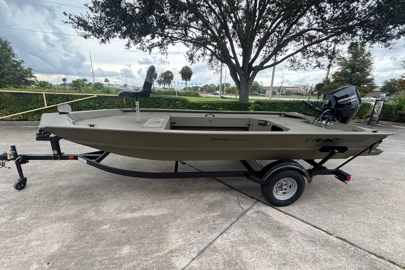 The Image of 2026 Tracker Grizzly 1654 T Sportsman boat on trailer, parked outdoors. - 0