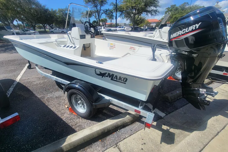 Slide: The Image of 2026 Mako Pro Skiff 15 CC boat with Mercury engine on trailer in parking lot. - 2