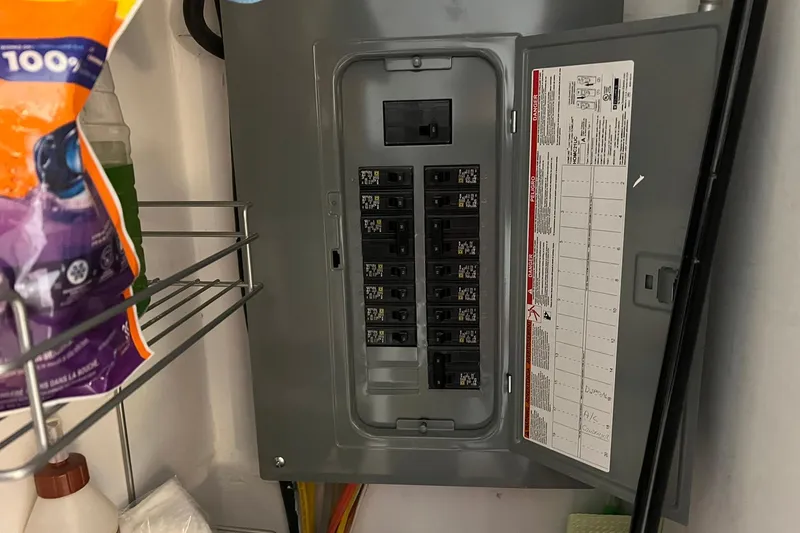 Slide: The Image of Electrical panel inside a 1981 Sumerset houseboat, with open door and visible circuit breakers. - 17