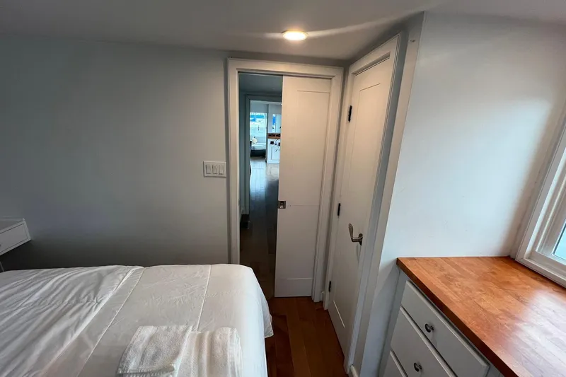 Slide: The Image of Interior of 1981 Sumerset houseboat bedroom with bed, wooden dresser, and hallway view. - 25
