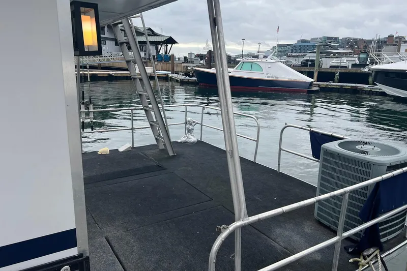 Slide: The Image of 1981 Sumerset houseboat deck with marina view, featuring railing and air conditioning unit. - 28
