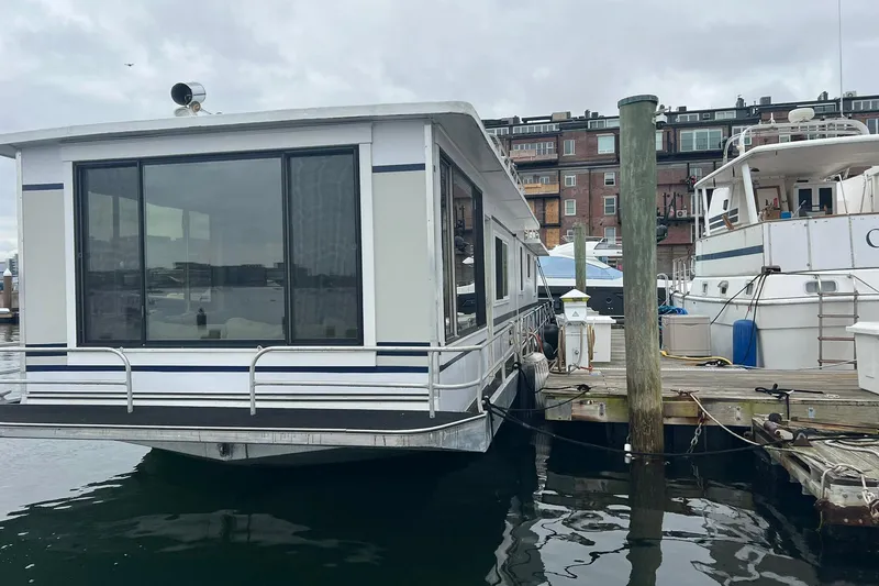 Slide: The Image of 1981 Sumerset houseboat docked at marina, featuring large windows and classic design. - 33