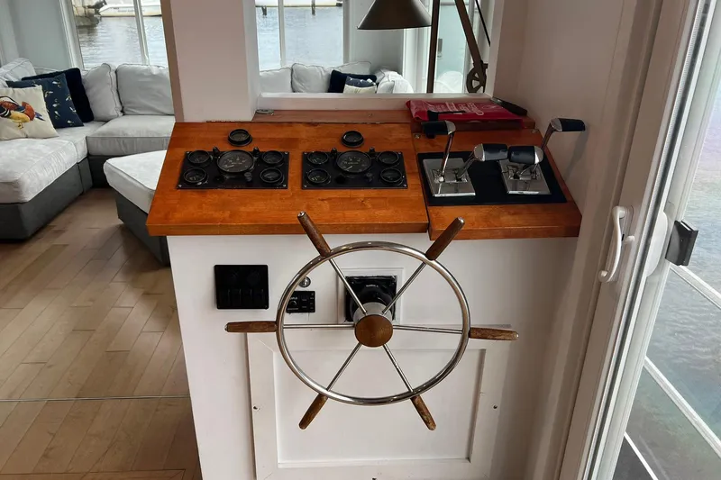 Slide: The Image of 1981 Sumerset Houseboat helm with wooden wheel and control panel, cozy interior view. - 5