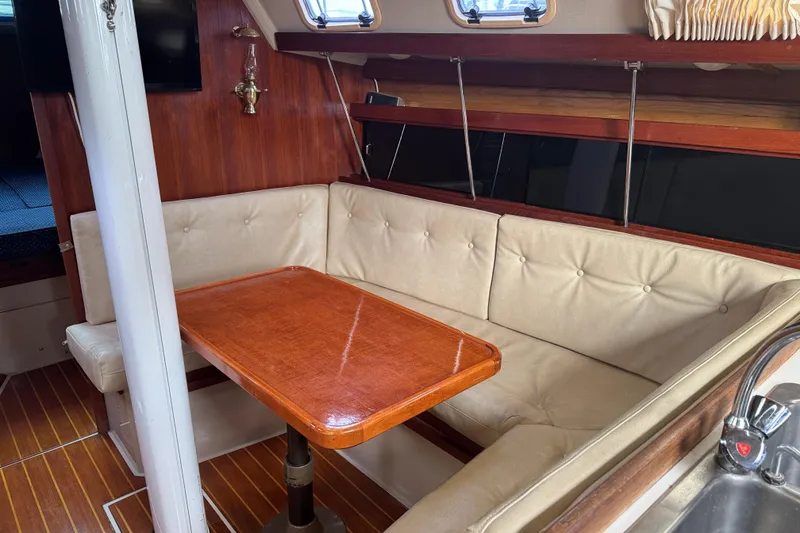 Slide: The Image of Interior of a 1988 Catalina 34 sailboat with a cozy dining area and wooden table. - 19