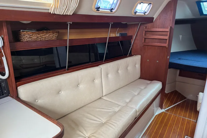 Slide: The Image of Interior of a 1988 Catalina 34 sailboat with cushioned seating and wooden accents. - 20