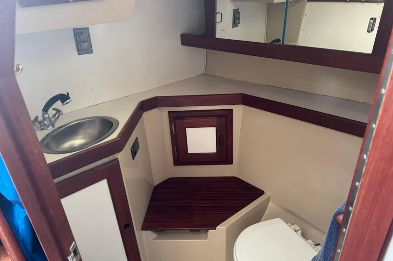 Slide: The Image of 1988 Catalina 34 yacht bathroom with sink, toilet, and wooden accents. - 23