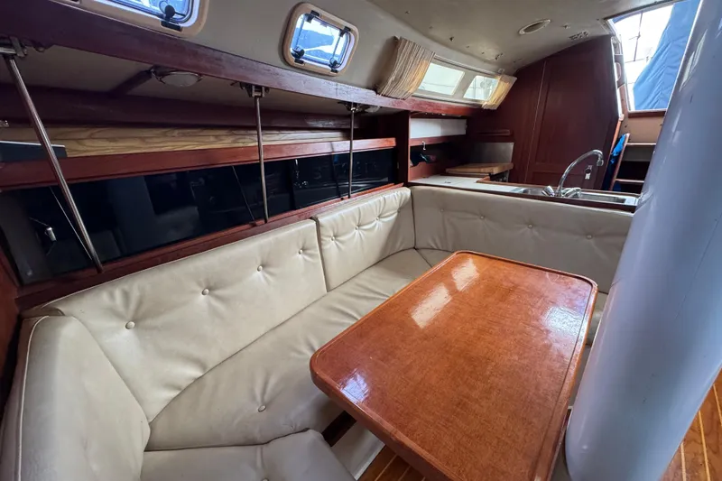 Slide: The Image of Interior of a 1988 Catalina 34 sailboat with cozy seating and wooden table. - 26