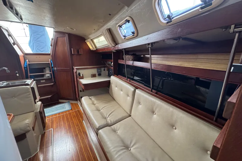 Slide: The Image of Interior of 1988 Catalina 34 sailboat with wood accents and beige seating. - 27