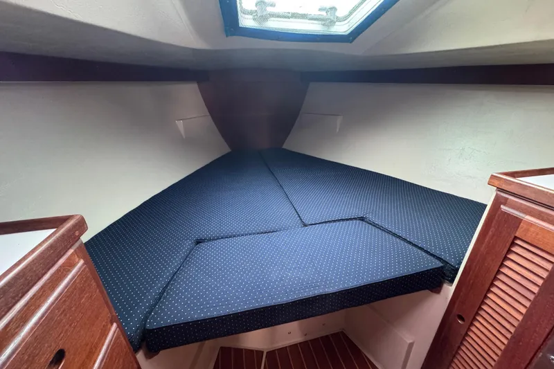 Slide: The Image of Interior cabin of 1988 Catalina 34 sailboat with cushioned V-berth and wooden cabinetry. - 28