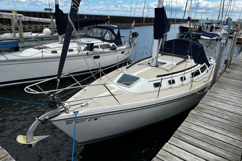 Slide: The Image of 1988 Catalina 34 sailboat docked at marina, featuring sleek design and spacious deck. - 3