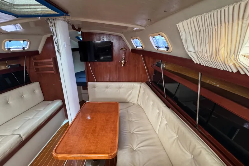 Slide: The Image of Interior of a 1988 Catalina 34 sailboat with cozy seating and wooden table. - 31
