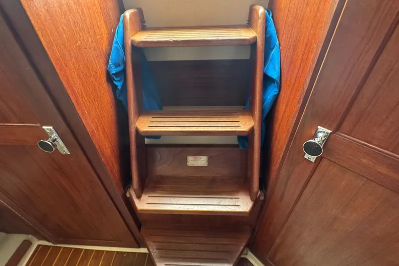 Slide: The Image of Wooden interior steps on a 1988 Catalina 34 sailboat, with blue fabric accents. - 32