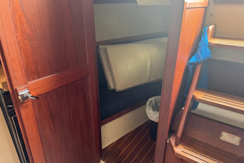 Slide: The Image of 1988 Catalina 34 sailboat interior with wooden door, steps, and cozy cabin space. - 34