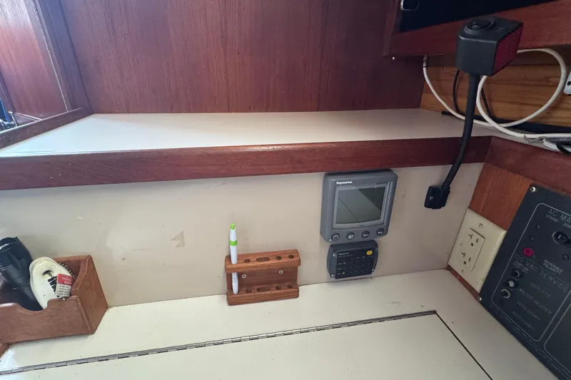 Slide: The Image of Navigation station inside a 1988 Catalina 34 sailboat with electronic equipment and storage. - 38