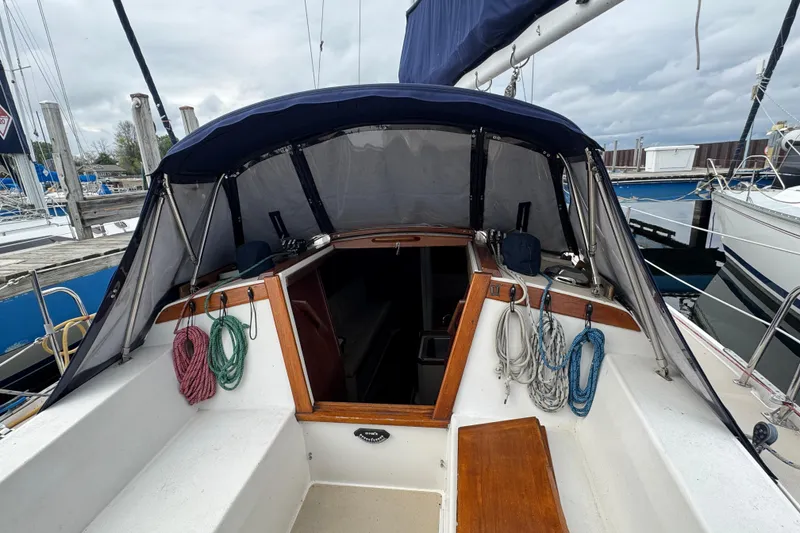 Slide: The Image of 1988 Catalina 34 sailboat cockpit with ropes and canopy, docked at marina. - 45