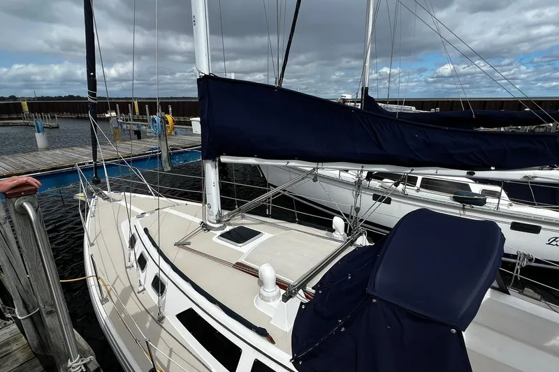 Slide: The Image of 1988 Catalina 34 sailboat docked at marina under cloudy sky. - 7