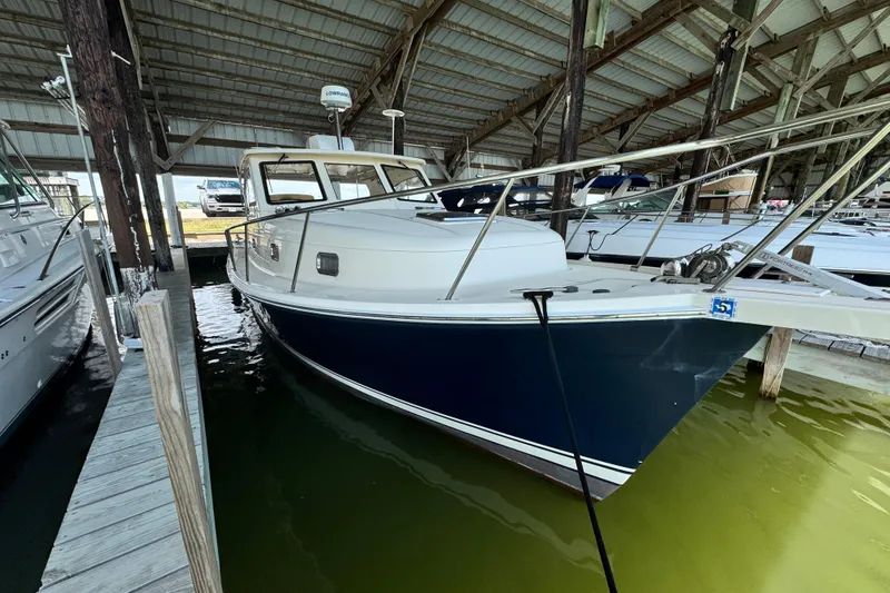 The Image of 2003 Mainship Pilot 34 boat docked in a covered marina. - 0