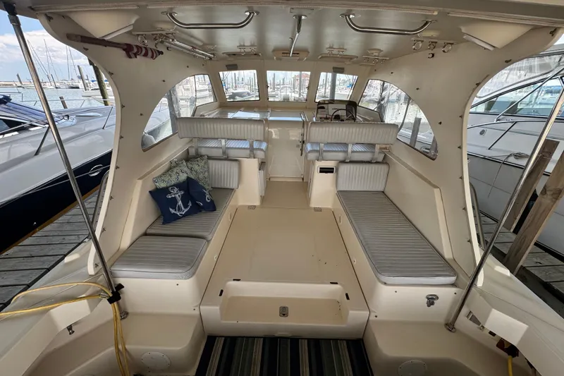 Slide: The Image of 2003 Mainship Pilot 34 boat interior with seating, nautical decor, and docked at marina. - 12