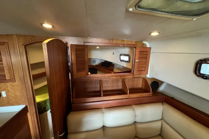 Slide: The Image of Interior of 2003 Mainship Pilot 34, featuring wood cabinetry and cozy seating area. - 21