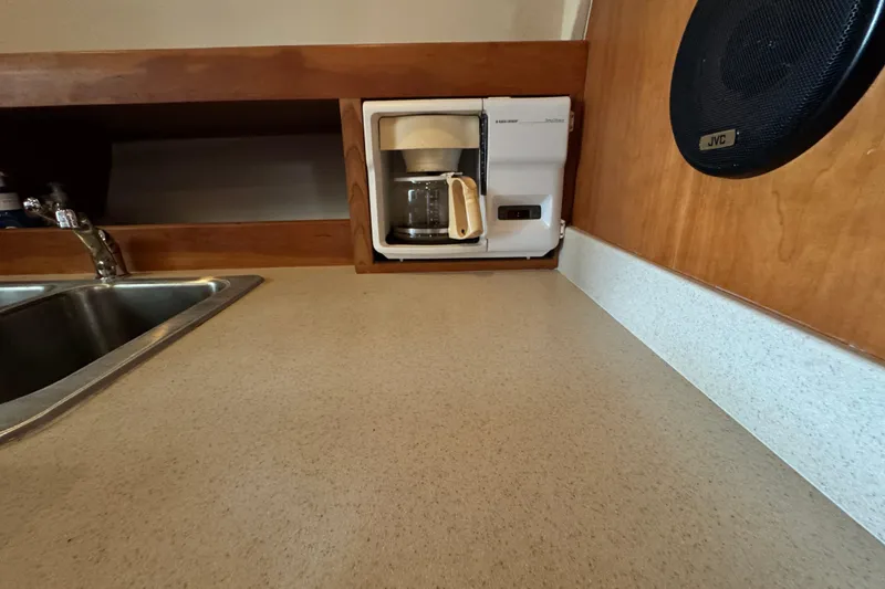 Slide: The Image of 2003 Mainship Pilot 34 galley with coffee maker, sink, and JVC speaker. - 25