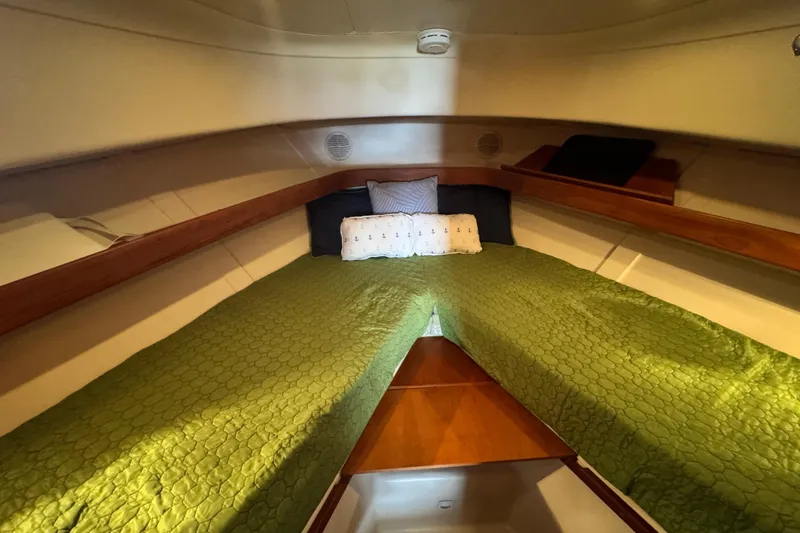 Slide: The Image of Cozy cabin interior of 2003 Mainship Pilot 34 with green bedding and wooden accents. - 29