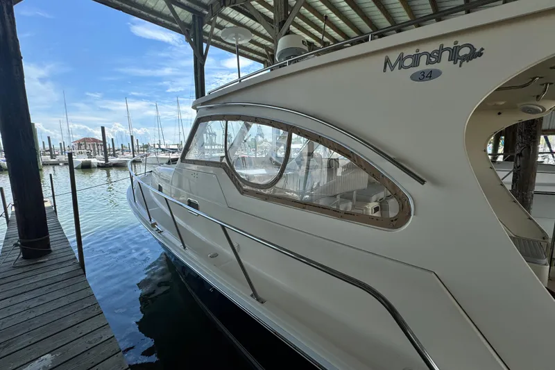 Slide: The Image of 2003 Mainship Pilot 34 docked in a marina under a covered structure. - 3