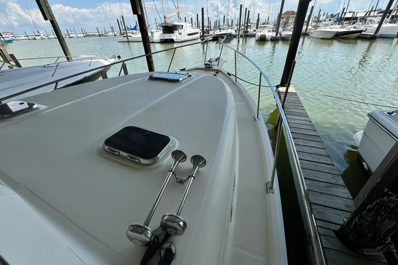 Slide: The Image of 2003 Mainship Pilot 34 docked at marina, showcasing deck and surrounding boats. - 4