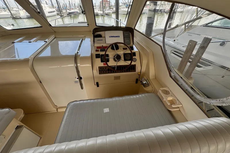 Slide: The Image of 2003 Mainship Pilot 34 helm with steering wheel and navigation equipment in marina setting. - 9