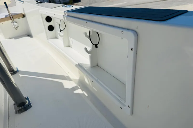 Slide: The Image of 2023 Banks Panga 23 Center Console interior detail, featuring storage compartments and rod holders. - 16