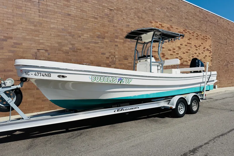 Slide: The Image of 2023 Banks Panga 26 Center Console boat on trailer, parked by brick wall. - 23