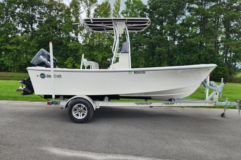 The Image of 2023 May-Craft 1900CC boat on trailer, parked on road with green trees in background. - 0