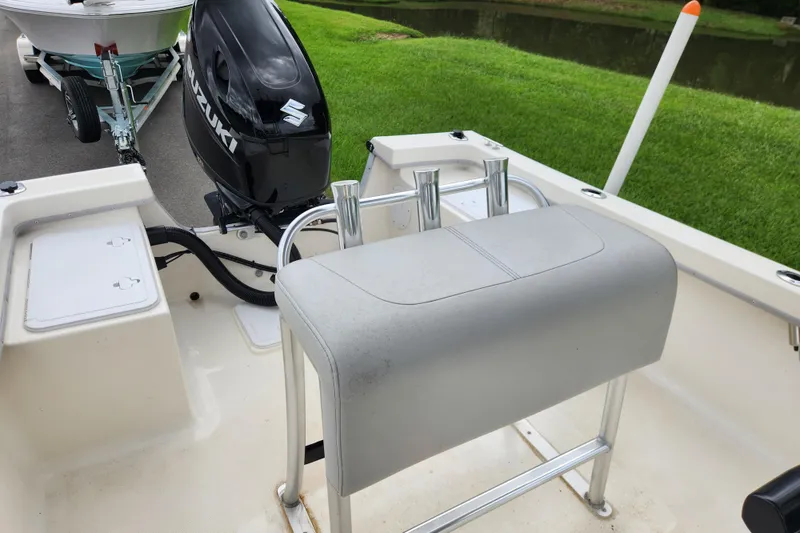 Slide: The Image of 2023 May-Craft 1900CC boat interior with Suzuki outboard motor, near grassy waterway. - 10