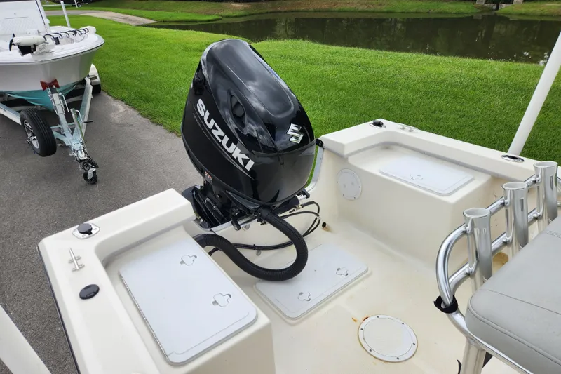 Slide: The Image of 2023 May-Craft 1900CC boat with Suzuki outboard motor, parked near a grassy area. - 11