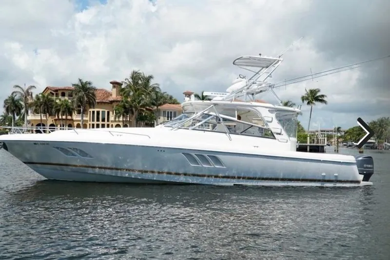 Slide: The Image of 2010 Intrepid 475 Sport Yacht cruising on a sunny day near luxury waterfront homes. - 1