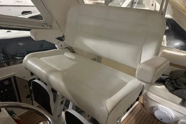 Slide: The Image of Captain's seat in 2010 Intrepid 475 Sport Yacht, featuring white upholstery and armrests. - 5