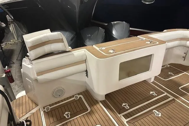 Slide: The Image of 2010 Intrepid 475 Sport Yacht deck with cushioned seating and teak flooring. - 7