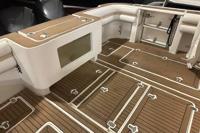 Slide: The Image of 2010 Intrepid 475 Sport Yacht deck with teak flooring and seating area. - 8