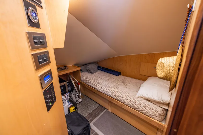 Slide: The Image of Cozy cabin interior of 2020 Viking 80 Convertible yacht with single bed and control panel. - 18