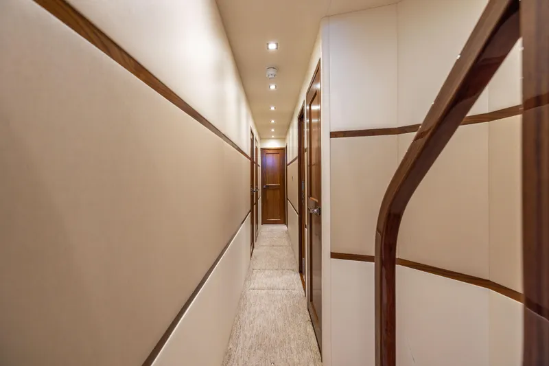 Slide: The Image of Luxurious hallway inside 2020 Viking 80 Convertible yacht, featuring elegant wood accents and soft lighting. - 19