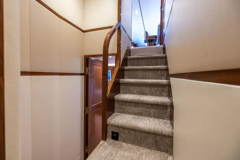 Slide: The Image of Interior staircase of 2020 Viking 80 Convertible yacht, featuring carpeted steps and wooden accents. - 20