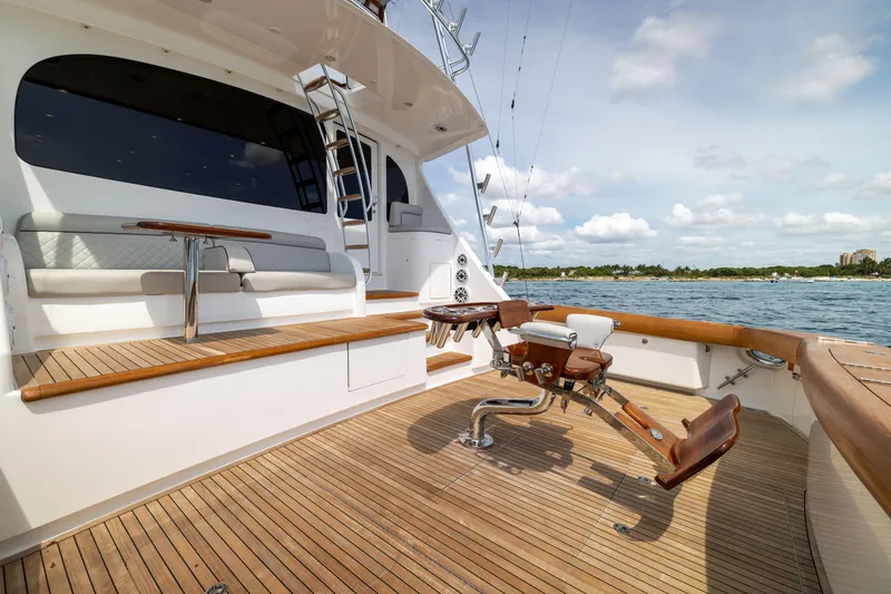 Slide: The Image of 2020 Viking 80 Convertible yacht deck with seating and fishing chair, overlooking serene waters. - 3