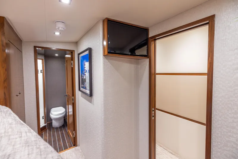 Slide: The Image of Interior of 2020 Viking 80 Convertible yacht, featuring a bathroom and hallway with modern decor. - 32