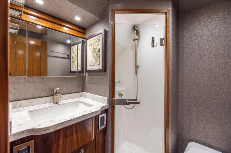Slide: The Image of Luxurious bathroom in 2020 Viking 80 Convertible yacht with marble sink and modern shower. - 33