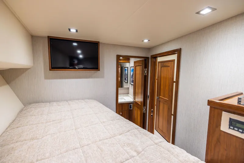 Slide: The Image of Luxurious bedroom interior of 2020 Viking 80 Convertible yacht with TV and wooden accents. - 34