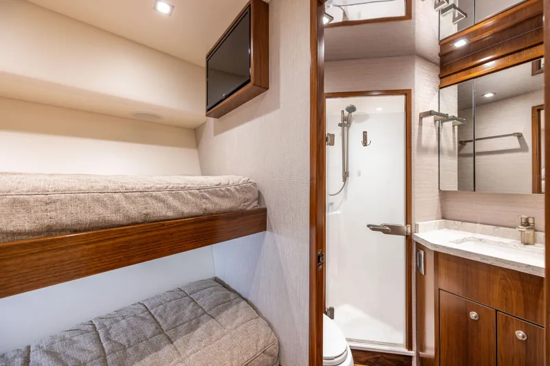 Slide: The Image of 2020 Viking 80 Convertible yacht interior with bunk beds and bathroom. - 35