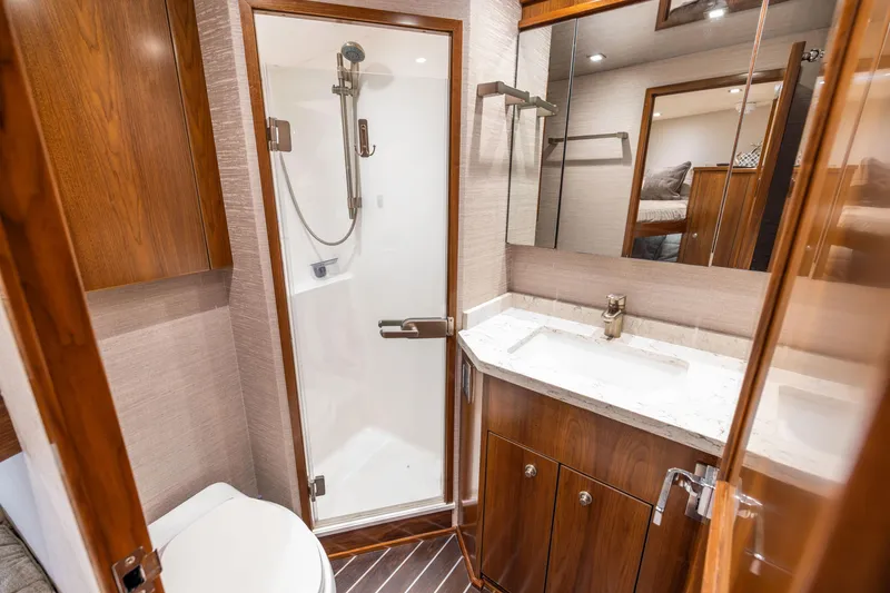 Slide: The Image of Luxurious bathroom in 2020 Viking 80 Convertible yacht with modern fixtures and wood accents. - 36