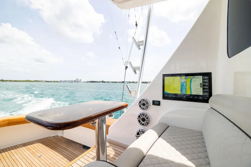 Slide: The Image of 2020 Viking 80 Convertible yacht interior with navigation screen, luxurious seating, and ocean view. - 48