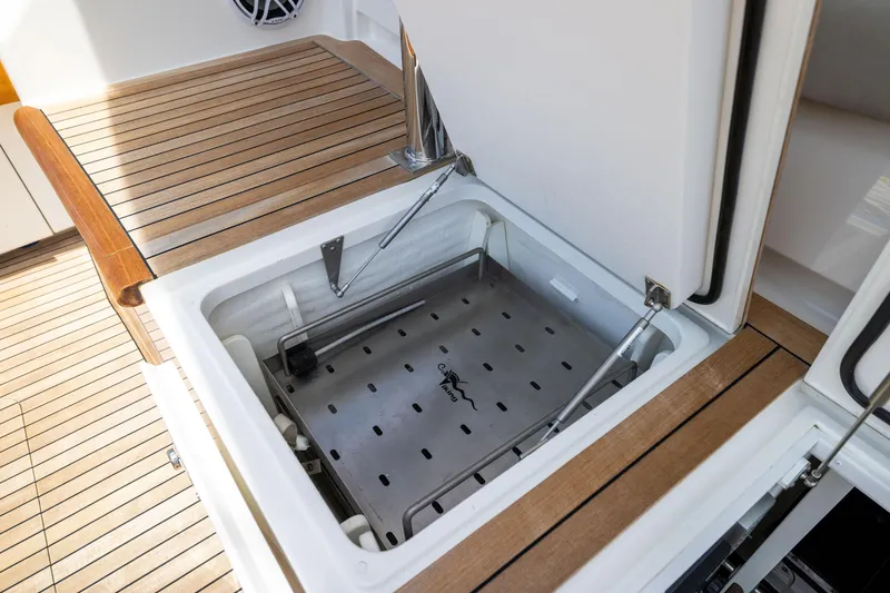 Slide: The Image of Open storage compartment on 2020 Viking 80 Convertible yacht with wooden deck. - 50